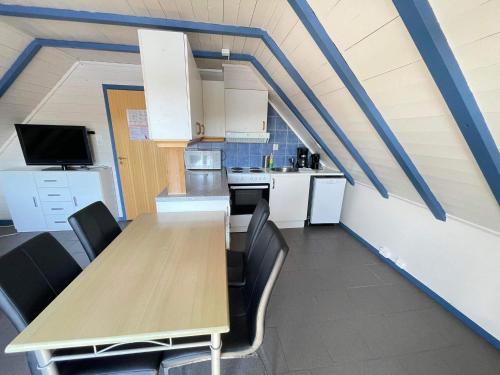 una cocina con una mesa de madera larga y sillas en Nautnes Seaside Apartments A5 en Nautnes