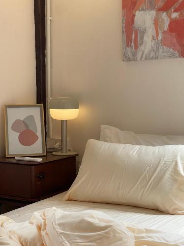 a bedroom with a bed with a lamp and a picture at The Ordinary 8 in Surat Thani