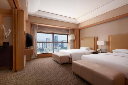 a hotel room with two beds and a large window at Ningbo Marriott Hotel in Ningbo