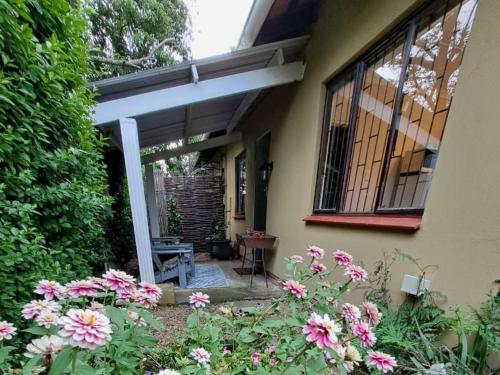 uma casa com flores cor-de-rosa em frente em Desiderata Cottage em Hilton