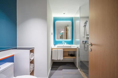 a bathroom with a sink and a mirror at Holiday Inn Express Jurong Xianlin in Zhenjiang