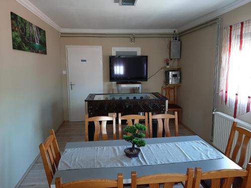 ein Esszimmer mit einem Tisch, Stühlen und einem TV in der Unterkunft Váradi Apartman in Abádszalók