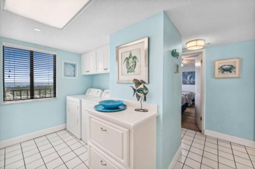 a kitchen with blue walls and a counter with a bowl on it at Commodore 1305 in Panama City Beach