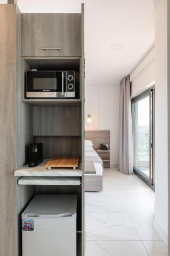 a kitchen with a microwave and a bed in a room at Sani Gulf I & II in Sani Beach