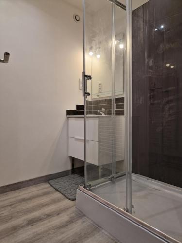 a bathroom with a glass shower and a sink at Maison de village en Provence in Sainte-Tulle