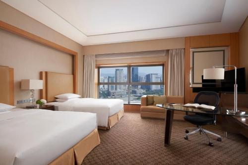 a hotel room with two beds and a desk at Ningbo Marriott Hotel in Ningbo