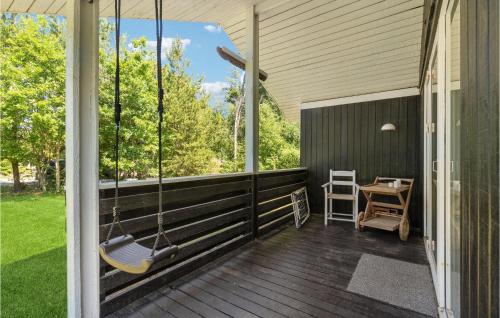 a porch with a swing and a table and chairs at Cozy Home In Ulfborg With Wifi in Ulfborg
