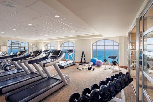 a gym with exercise equipment and the ocean in the background at JW Marriott Cancun Resort & Spa in Cancún
