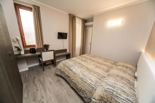 a hotel room with a bed and a desk and a window at B&B Corte sul Naviglio CIN I T 0 1 5 0 7 0 C 1 3 X U I L Q C V in Cernusco sul Naviglio