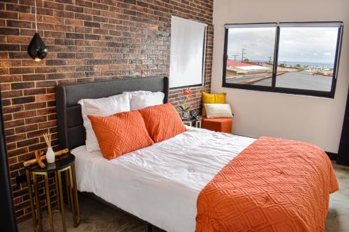 a bedroom with a bed and a brick wall at Moderno, cómodo y lindo departamento en Tijuana BC in Tijuana