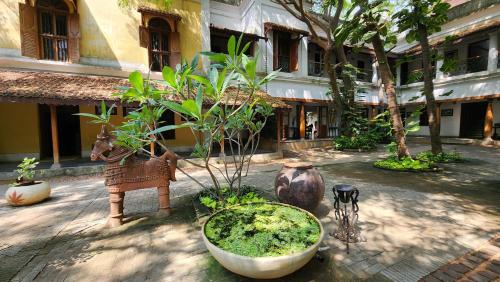 a courtyard with various plants and a building at Kariappa House in Puducherry
