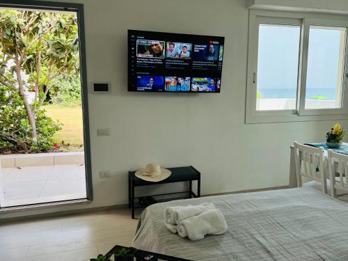 um quarto com uma cama e uma televisão na parede em Beach Loft Poetto em Quartu SantʼElena