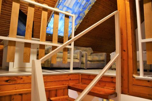 a staircase in a log cabin with a couch at Unicum Vendégház in Abádszalók