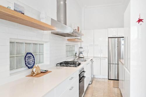 cocina blanca con fogones y nevera en Coogee 2 Bedroom Escape - New listing, en Sídney