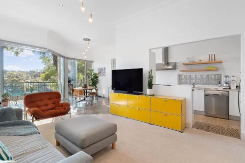 a living room with a yellow cabinet and a kitchen at Coogee 2 Bedroom Escape - New listing in Sydney