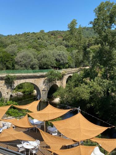 a bridge with a bunch of tents in front of a bridge at Auberge U Mulinu in Casalabriva