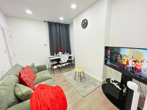 a living room with a couch and a flat screen tv at Opal Apartment in Leicester