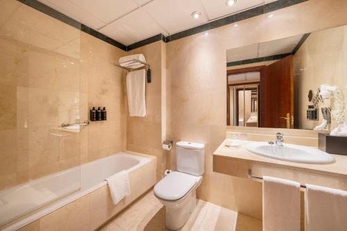 a bathroom with a tub and a toilet and a sink at Eurostars Plaza Acueducto in Segovia