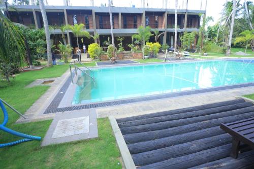 a large swimming pool in front of a building at Hotel Riverrina in Negombo