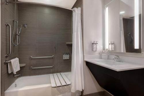 ein Bad mit einer Badewanne, einem Waschbecken und einer Dusche in der Unterkunft Holiday Inn Express & Suites - Kansas City KU Medical Center, an IHG Hotel in Kansas City