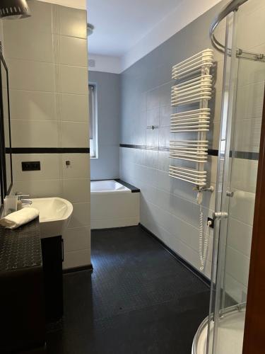 een badkamer met een douche, een wastafel en een bad bij Apartament Syrokomli 3 in Gdynia