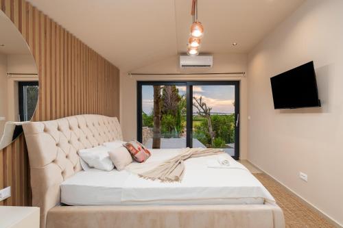 Schlafzimmer mit einem großen weißen Bett und einem großen Fenster in der Unterkunft Villa Slatina near Zrce beach in Novalja