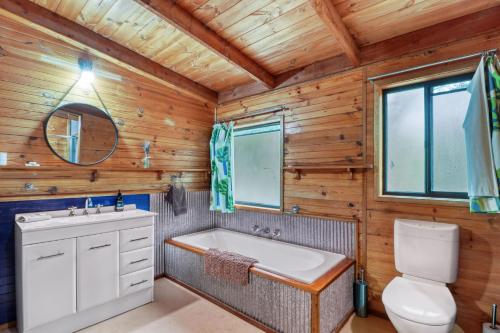 een badkamer met een bad, een toilet en een wastafel bij The Bower in Merrijig