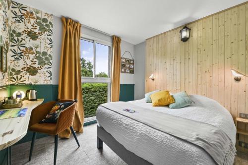 a bedroom with a bed and a desk and a window at Logis Hôtel & Restaurant Ludik in Bergerac