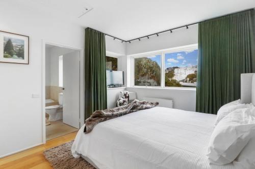 a bedroom with a large bed with green curtains at MarkII 4 West in Mount Buller