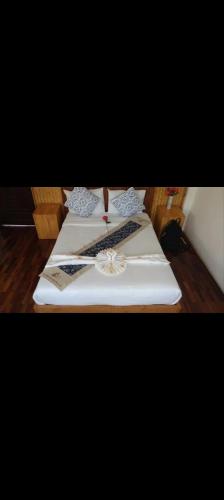 a group of three white beds sitting on a wooden floor at Pai Woodland Resort in Pai
