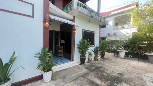 a house with potted plants in front of a door at Lotus Blanc Homestay in Battambang