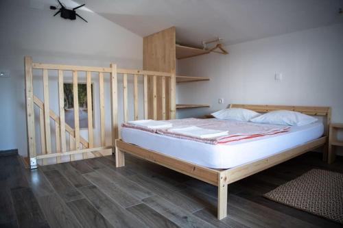 1 dormitorio con 1 cama con marco de madera en Duplex Apartma Nikolina, en Spodnje Jarše
