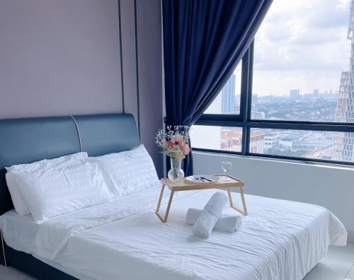 een bed met een tafel voor een groot raam bij Sunway Greenfield Residence 3R2B w/Netflix in Petaling Jaya