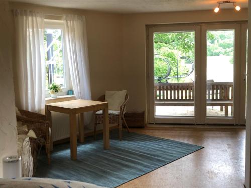 a living room with a table and a balcony at Ankommen und wohlfühlen, wie zu Hause in Hamburg