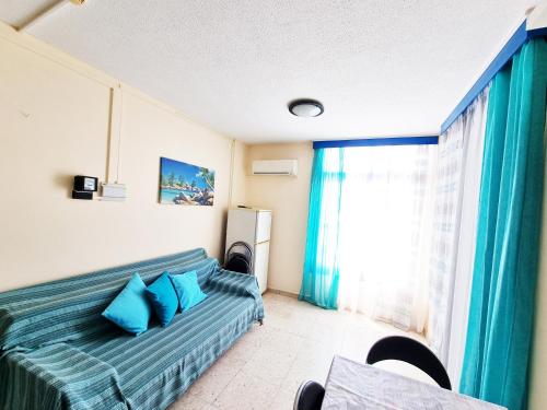 - une chambre avec un lit doté d'oreillers bleus et d'une fenêtre dans l'établissement 603 Agia Napa Center, à Ayia Napa