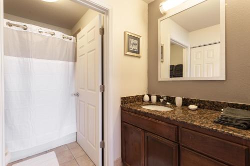 bagno con lavandino e specchio di Cozy Apartment by La Cantera & Rim a San Antonio