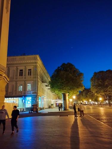 a group of people walking down a street at night at In the heart of Odessa in Odesa