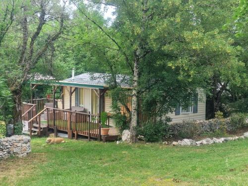 une maison avec un chien couchant dans la cour dans l'établissement Petit coin tranquille, à Brengues