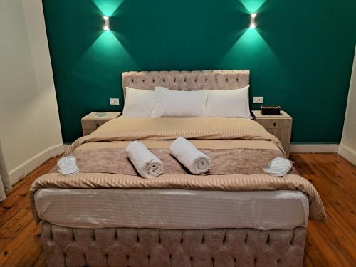 a bedroom with a large bed with a green wall at downtown Family Suites in Cairo