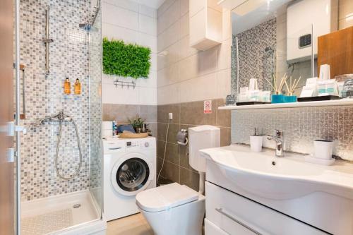 een badkamer met een wastafel en een wasmachine bij Mediterranea private pool apartment in Solin