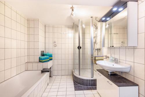 biała łazienka z umywalką i prysznicem w obiekcie Alb Rose Ferienwohnung w mieście Sonnenbühl