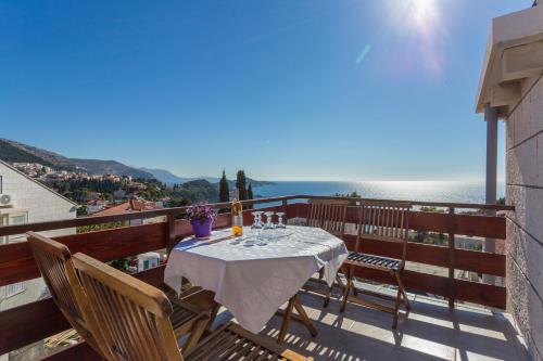 a table on a balcony with a view of the ocean at Apartment Lise in Dubrovnik