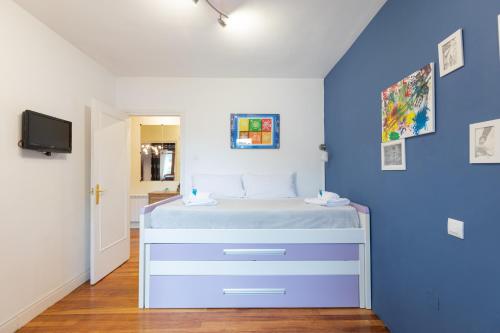 a bedroom with a bed with a blue wall at Artibai - baskeyrentals in Ondárroa