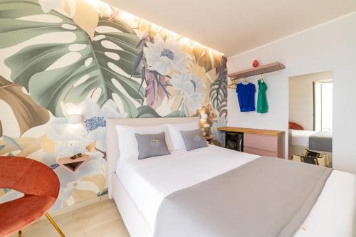 a bedroom with a white bed and a floral wall at Naxos Marina Bay in Giardini Naxos