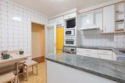 a kitchen with white cabinets and a counter top at Artibai - baskeyrentals in Ondárroa