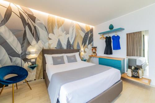 a bedroom with a large bed and a blue chair at Naxos Marina Bay in Giardini Naxos