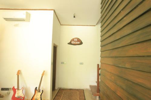 a hallway with two guitars and a sign on the wall at Hotel Riverrina in Negombo