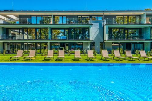 a building with chairs and a pool in front of it at H55 in Balatonlelle