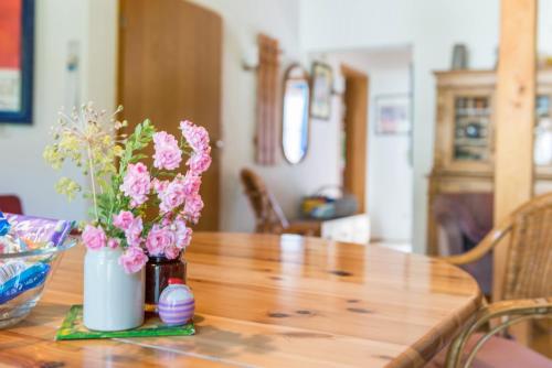 a wooden table with two vases of flowers on it at Rose Garden in Heiligenberg