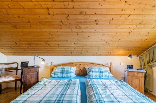 a bedroom with a bed and a wooden ceiling at Rose Garden in Heiligenberg